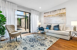 Living Room: High vaulted ceiling and glass doors opens on to the outdoor living space.