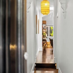 HALL: Enter the hall and you are immediately struck by the original Victorian features and original artwork which opens on to the two front bedrooms and on to the large rear open plan living/dining/kitchen.