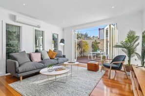 LIVING ROOM: Spacious family room with large comfortable couch Smart TV, Netflix, Sonos and sunny courtyard outlook. 