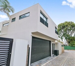 MODERN LOFT APARTMENT: View of apartment windows with jungle garden and tree outlook. The garage is available for car parking on request. 