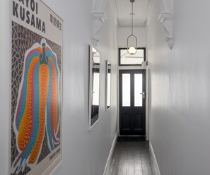 HALL: The hall opens out to the meals area and kitchen. Original artwork hang on the walls.