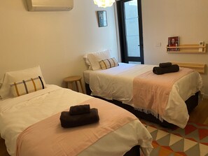 BEDROOM 2: Large bedroom with two extra long single beds with light court outlook. Built in cupboards.  Air conditioned. 