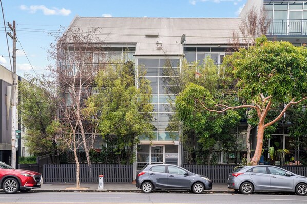 FRONT: The two bedroom apartment is on the left side of the first floor with a balcony and tree outlook over Lygon Street. 