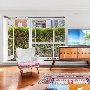 LOUNGE: The space is tastefully decorated with a collection of original furniture including an original cabinet by Schulim Krimper, a renowned Melbourne furniture designer, a classic mid-century designer armchair. Smart TV and sound bar.