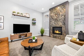 Open living room with gas fireplace and Smart TV
