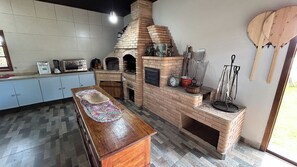 Cozinha casa da piscina  Forno e fogão à lenha, aparador e utensílios