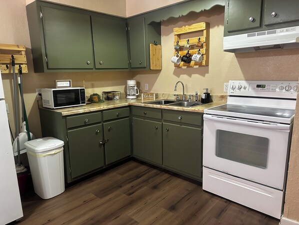 Full kitchen with stove, oven, microwave, coffee maker and other kitchen essentials for long stays.