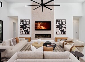 Unit 1: Grand open-concept living space with designer decor, featuring a fireplace and Smart TV.
