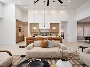 Unit 1: Grand open-concept living space with designer decor, featuring a fireplace and Smart TV.