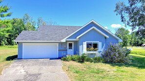 Our blue cottage with a blanket of stars above at night and attached garage.