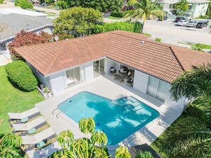 A refreshing pool area set in a landscaped yard, with plenty of space for sunbathing and outdoor gatherings.