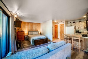 Studio with open living area, kitchen, bed, and full sized bath.