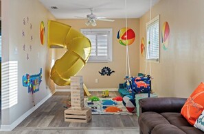 Kid's Dream Playroom: Fun-filled space with a slide, jumbo Jenga, and a variety of toys for endless entertainment.