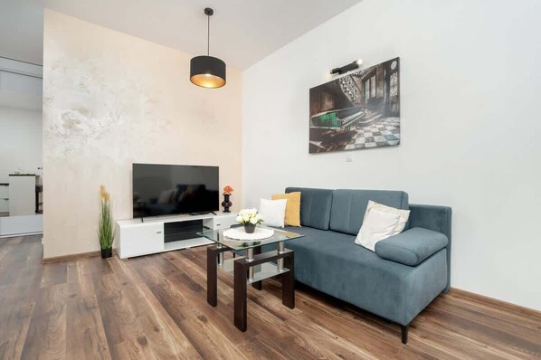 Salon z sofą dla jednej osoby, telewizor z funkcją Smart TV, stolik kawowy
