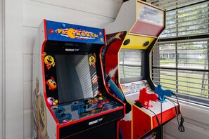 The game room features a selection of arcade games, perfect for a fun and nostalgic gaming experience