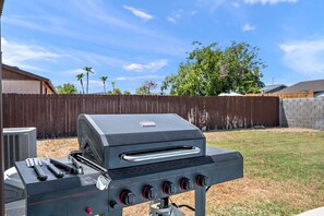 Relax in the backyard oasis with a BBQ grill and refreshing pool.