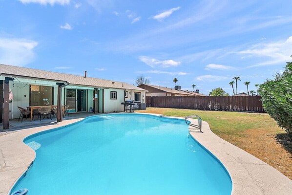 Relax in the backyard oasis with a BBQ grill and refreshing pool.