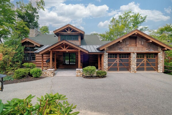 Charming rustic cabin with a welcoming front porch, stone accents, and a spacious three-car garage. Surrounded by nature, this mountain retreat offers a peaceful getaway with modern amenities and cozy charm.