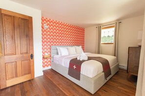 Rest peacefully in the primary bedroom featuring a plush king-sized bed and luxurious linens, all set against a backdrop of historic charm.