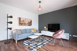 Living room with a cosy couch, big flat screen television and fast Wi-Fi. 