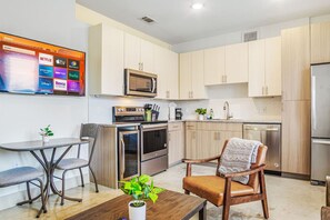 Bright and airy living room with plush seating, a large TV, and tasteful decor, creating the perfect space for relaxation and entertainment.