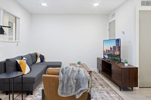 The living room’s cozy vibe makes it the perfect spot to relax, with ample seating and a warm ambiance.