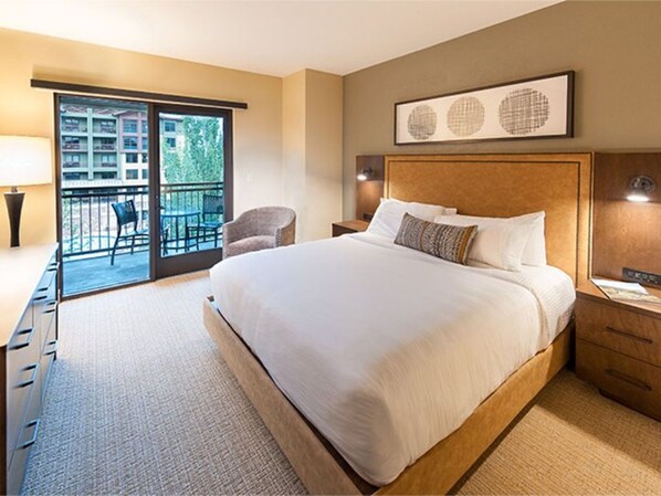 Cozy bedroom with natural light and a plush queen bed.