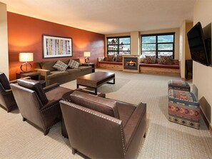 Spacious living room with modern decor and large windows.