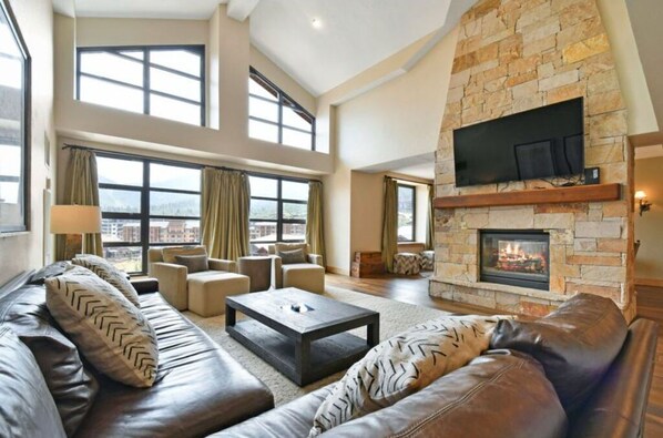 Cozy living room with a stone fireplace and plush seating.