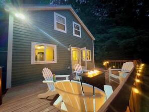 Firepit surrounded by 4 Adirondack chairs.