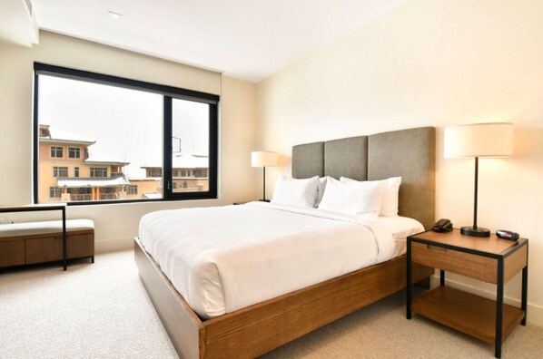 Bright bedroom with a king bed and large windows.