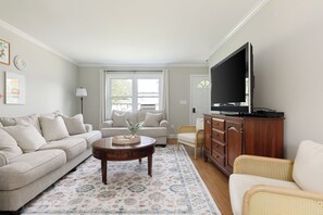 A cozy living room with neutral tones and abundant natural light—perfect for gathering with friends and family.