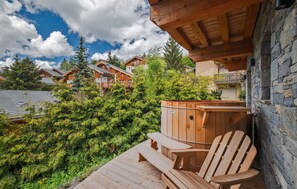 Unwind in the private outdoor hot tub, surrounded by nature and serene mountain views.