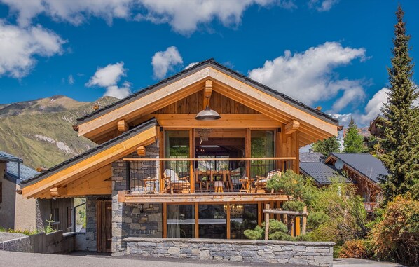 Experience the charm of alpine living in this stunning chalet, featuring expansive windows and a spacious balcony that offer breathtaking mountain views. 
