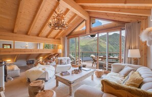 Cosy up in this elegant living room with stunning mountain views and a balcony perfect for enjoying the serene landscape.