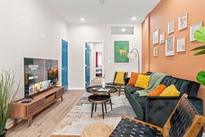 Enjoy a vibrant living area with a sleek TV, stylish furnishings, and eclectic decor. The cozy seating area is perfect for relaxation, while colorful accents and modern art create a welcoming and lively ambiance. Ideal for a memorable stay!