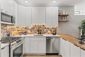 The vibrant and unique tile backsplash adds personality to this well-appointed kitchen. You will appreciate the convenience and style of this space, perfect for creating delicious meals.
