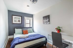 Cozy Room Featuring A Queen Bed And Desk Workspace