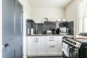 Fully Equipped Kitchen With Sleek Countertops And Essential Appliances