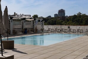 Outdoor infinity pool, lounge chairs, umbrellas and cabanas