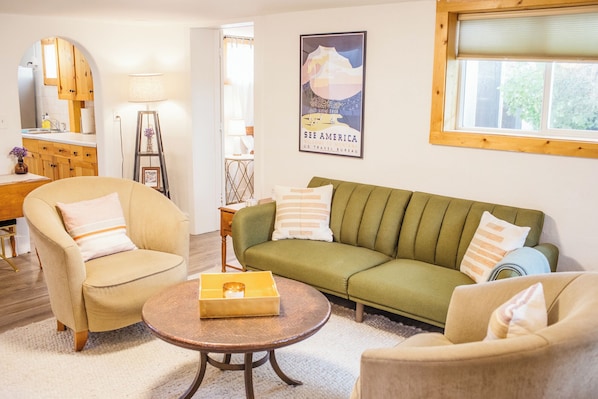 Bright and open living room with a couch that turns into a fold-out bed.
