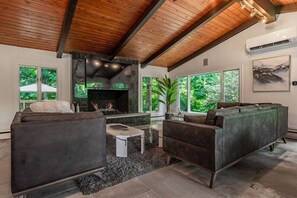 Couches seating for nine, custom quartz coffee tables, Gas fireplace, and TV