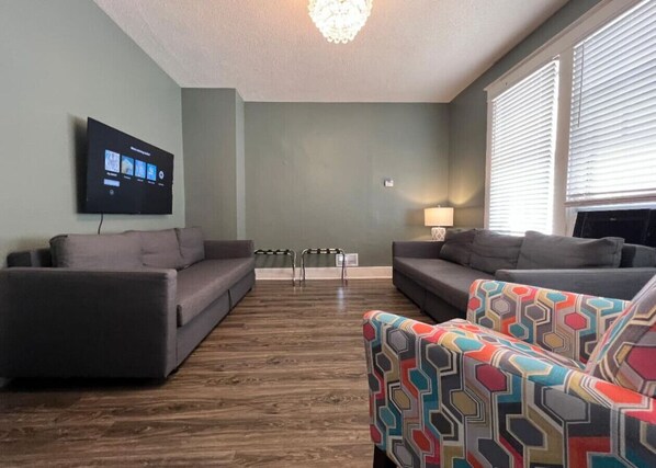Bright and airy living room with plush seating, a large TV, and tasteful decor, creating the perfect space for relaxation and entertainment.