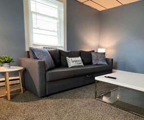 The living room’s cozy vibe makes it the perfect spot to relax, with ample seating and a warm ambiance.