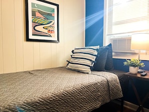 You feel enveloped in comfort as you relax on the twin bed, surrounded by a room designed for tranquility.