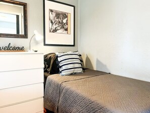 The twin bedroom serene ambiance invites you to relax, with a plush bed that promises a restful night's sleep.