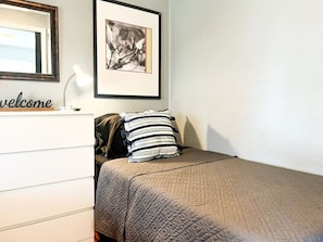 The twin bedroom serene ambiance invites you to relax, with a plush bed that promises a restful night's sleep.