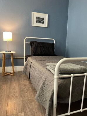 The twin bedroom serene ambiance invites you to relax, with a plush bed that promises a restful night's sleep.