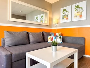 The living room’s cozy vibe makes it the perfect spot to relax, with ample seating and a warm ambiance.