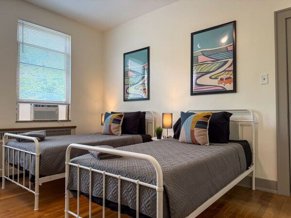 The twin bedroom serene ambiance invites you to relax, with a plush bed that promises a restful night's sleep.